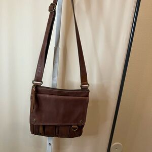 Fossil tan lleather crossbody purse with multiple compartments. Front flap snap